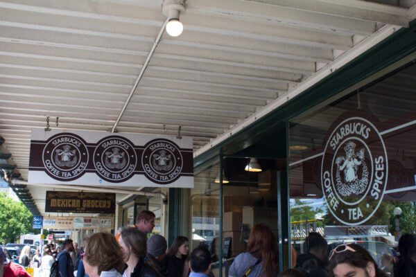 Starbucks Coffee entrance with several Starbucks signs hanging up