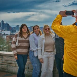 A Tours Northwest guide take a picture of a group of people in front of the Seattle skyline