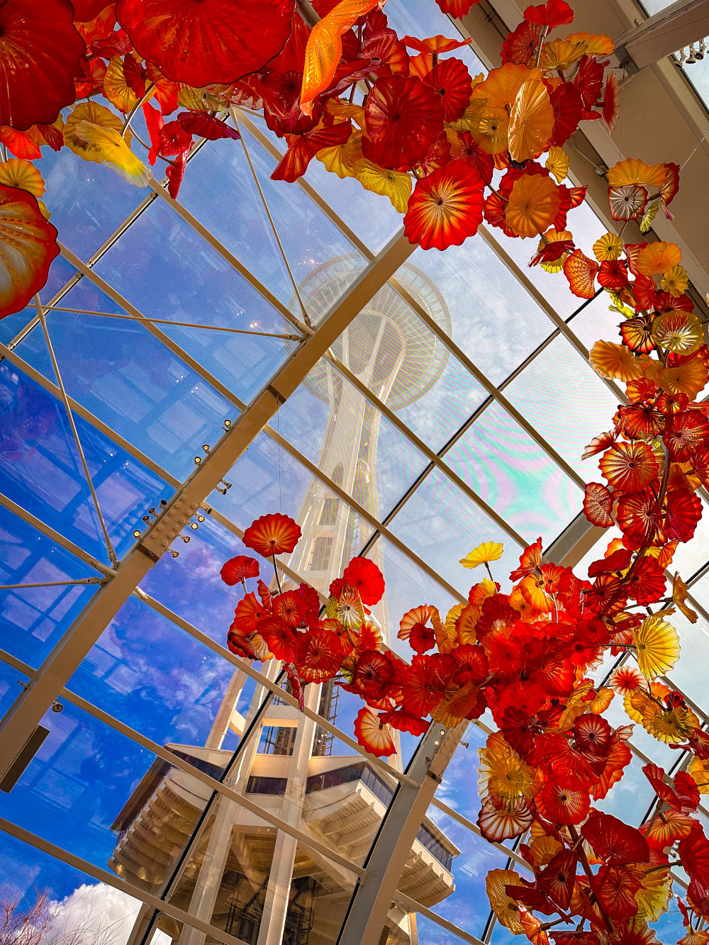 Space Needle seen through spray of glass flowers in Chihuly Garden