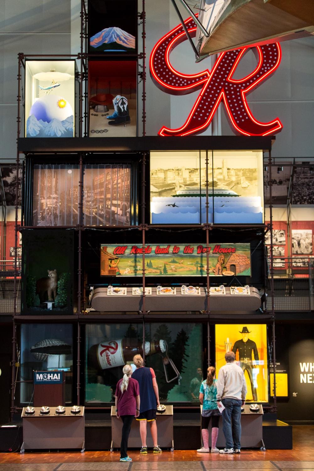 various screens and a giant neon R on the wall of the MOHAI atrium