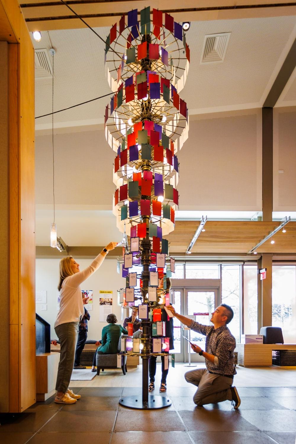 A man and a woman examine cards on different sides of a colorful inverted-pyramid installation Seattle Culture from Seattle Premier Attractions